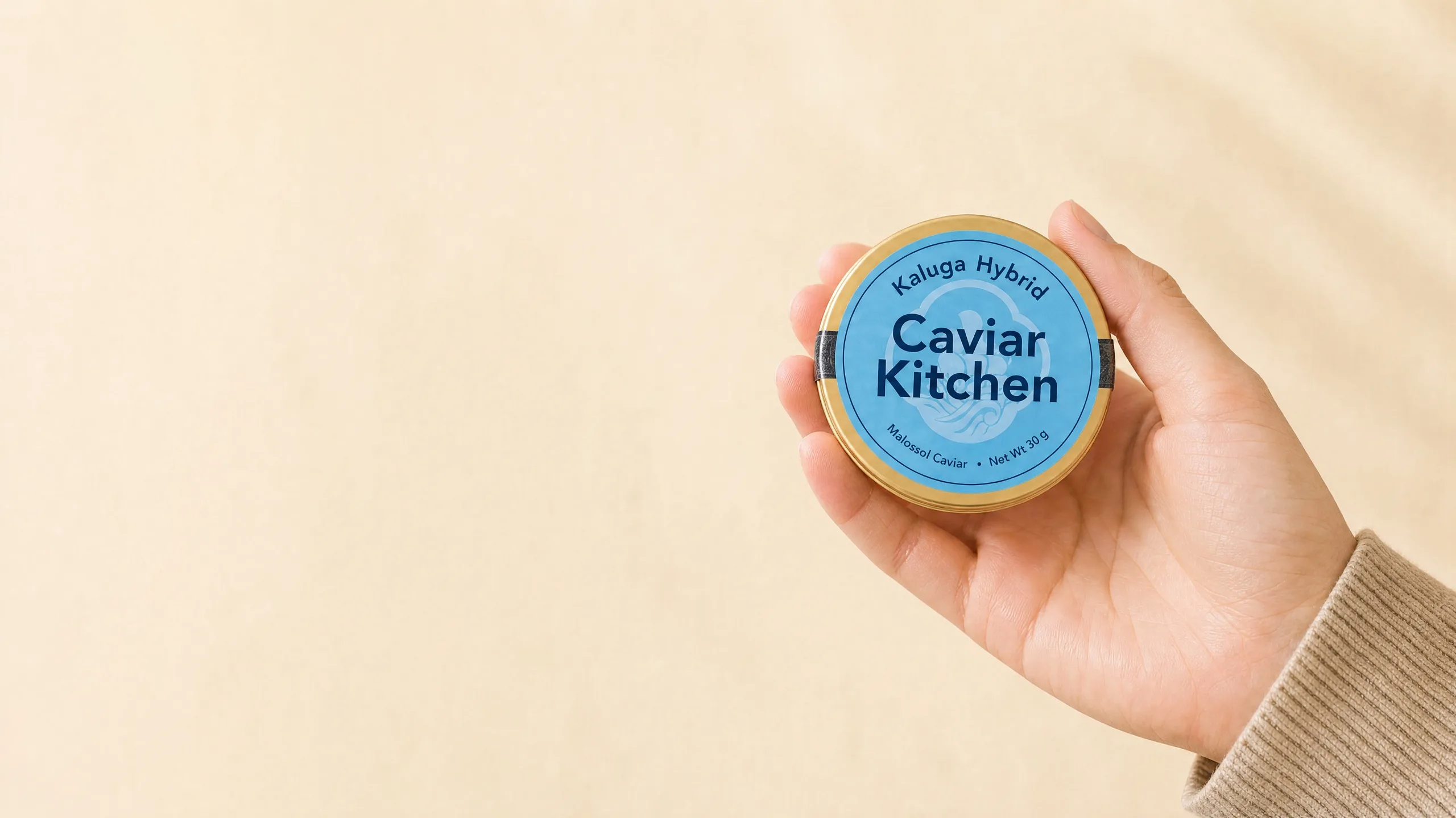 A hand holding a Caviar Kitchen Kaluga Hybrid tin with its species name on the label.